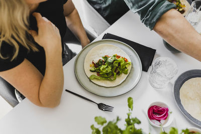 Woman having tortilla with various toppings