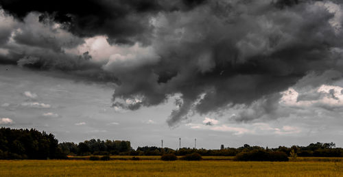 Scenic view of field against cloudy sky