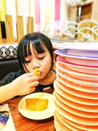 Close-up of girl eating food on table