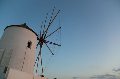 Low angle view of traditional windmill against clear blue sky