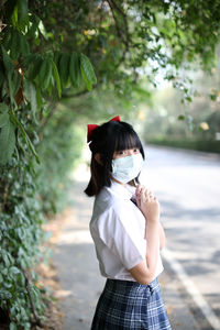 Portrait of young woman wearing mask standing outdoors