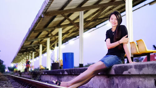 Portrait of mature woman sitting at railroad