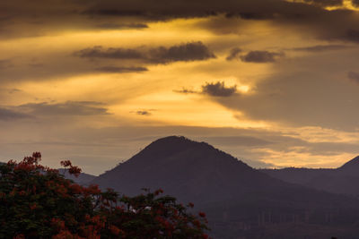 Scenic view of silhouette mountains against orange sky