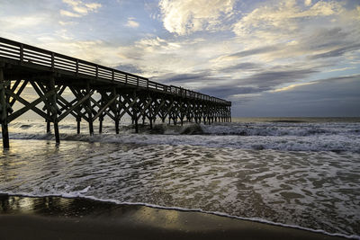 Pier over sea against sky during sunset