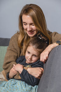 Portrait of young woman sitting on bed at home