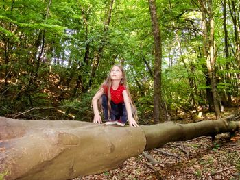 Full length of woman sitting in forest