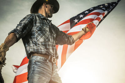 Rear view of man holding american flag