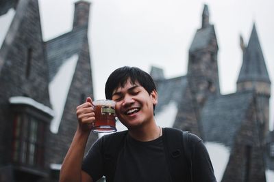 Portrait of smiling young man holding camera