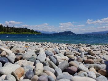 Pebbles on beach against sky