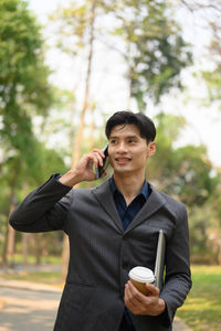 Young woman using mobile phone while standing outdoors