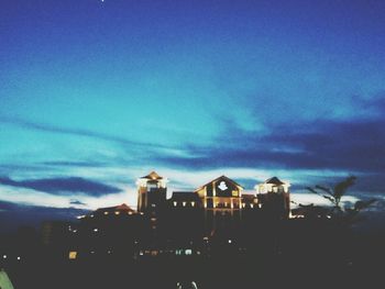 Buildings in city against cloudy sky