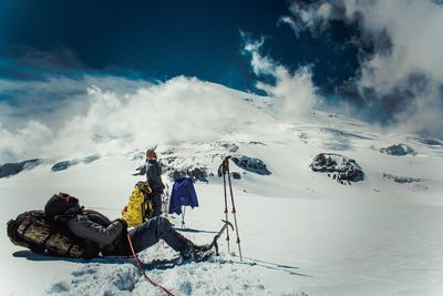 People skiing on snowcapped mountain against sky