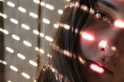 Close-up portrait of young woman against wall