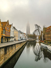 Canal amidst buildings against sky