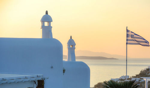 Lighthouse by sea against sky