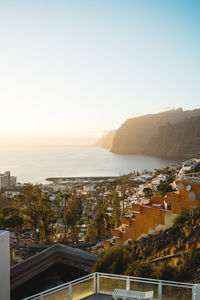 High angle view of townscape by sea against clear sky