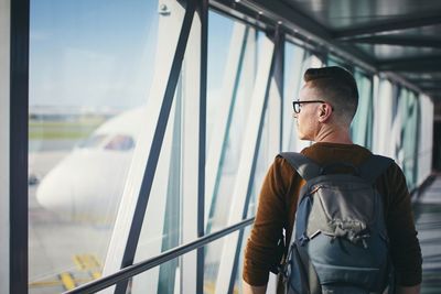 Man looking away while standing on window