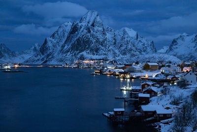 Scenic view of sea by snowcapped mountains against sky