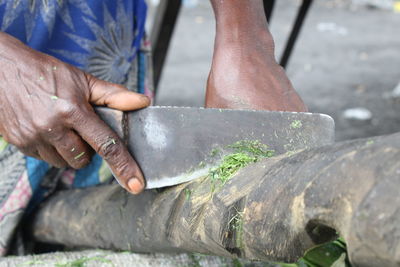 Midsection of person cutting wood