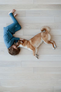 People and pets. top view of cute happy boy hugging his furry best friend shiba inu dog