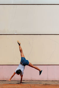 Full length rear view of man skateboarding on wall