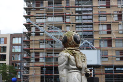 Statue against buildings in city