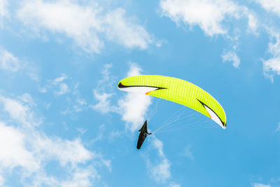 Low angle view of person paragliding against sky