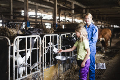 Woman and daughter in cowshed