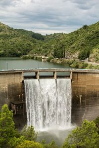 Scenic view of waterfall against sky