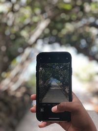 Hand holding smart phone outdoors