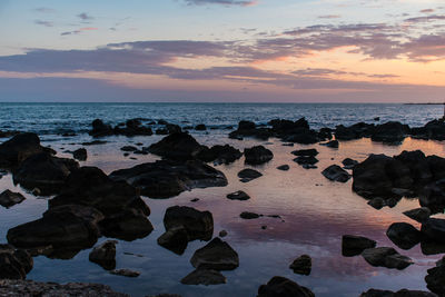 Rocks on shore during sunset