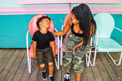 Smiling mother and son sitting on chairs