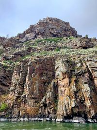 Low angle view of rock formation in sea against sky