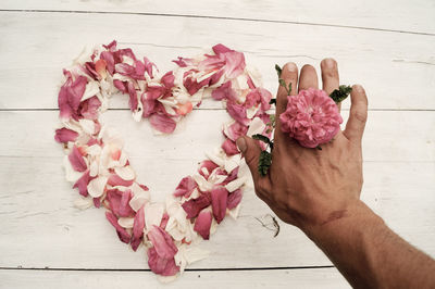 Cropped hand holding pink flower