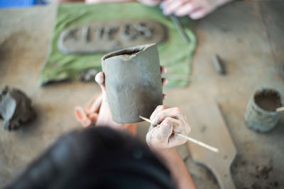 High angle view of person making art on earthenware 