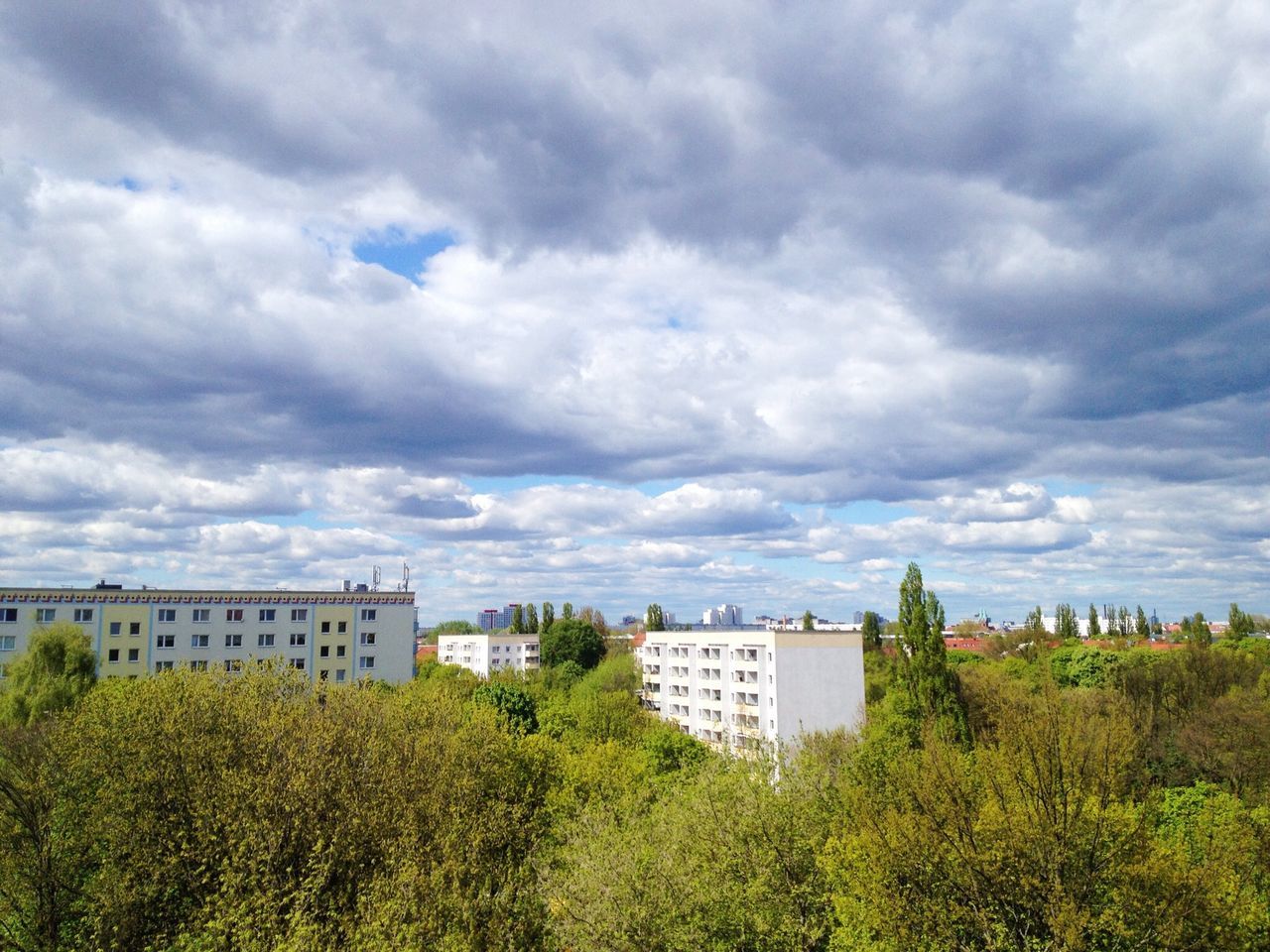 building exterior, sky, architecture, cloud - sky, built structure, cloudy, tree, weather, overcast, cloud, house, growth, green color, nature, storm cloud, residential structure, plant, residential building, field, beauty in nature