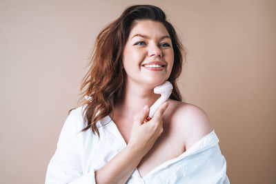 Portrait of smiling young woman drinking milk at home