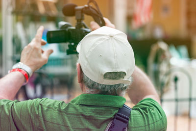 Rear view of man photographing with mobile phone