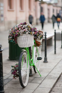 Flowers in basket on footpath by street