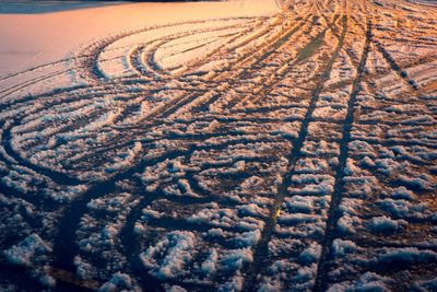 High angle view of tire tracks on field