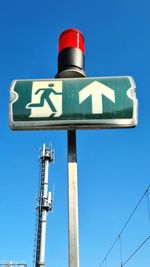 Low angle view of road sign against blue sky