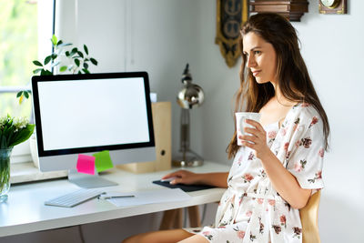 Woman looking away while working at home