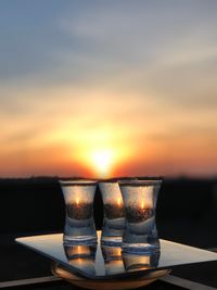 Close-up of drink on table against sky during sunset
