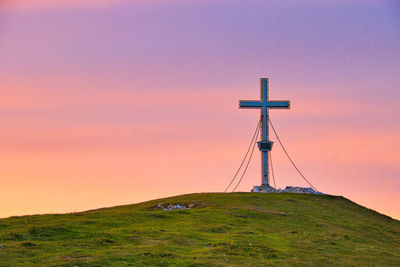 Windmill on field against sky during sunset