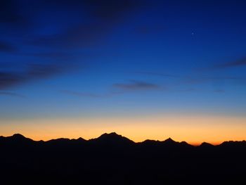 Scenic view of silhouette mountains against sky at sunset