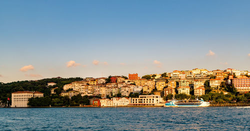 View of townscape by sea against sky