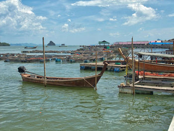Sailboats moored on sea against sky