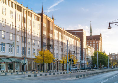 Street by buildings against sky in city