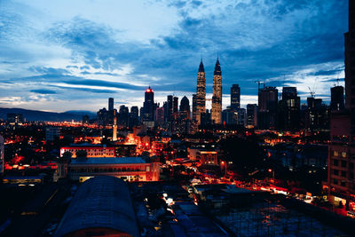 Illuminated buildings in city at dusk