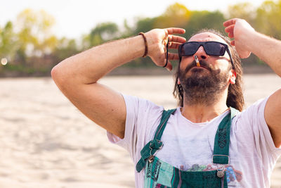 Portrait of man wearing sunglasses standing outdoors